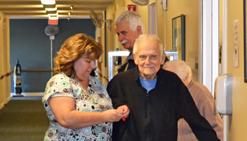 Assisting a resident to walk down the hall.